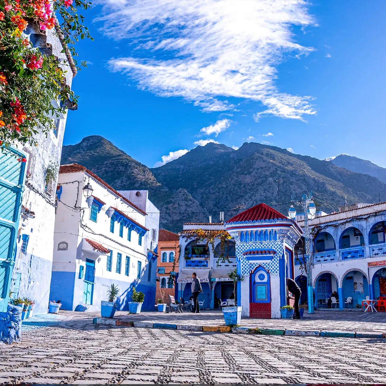 Chefchaouen Blue City square with traditional buildings and Rif Mountains