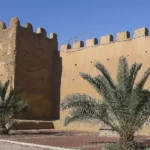 Earthen city walls of Taroudant City with crenelated ramparts.